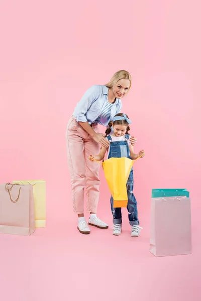 Full Längd Glad Mor Och Leende Dotter Tittar Shopping Väska — Stockfoto