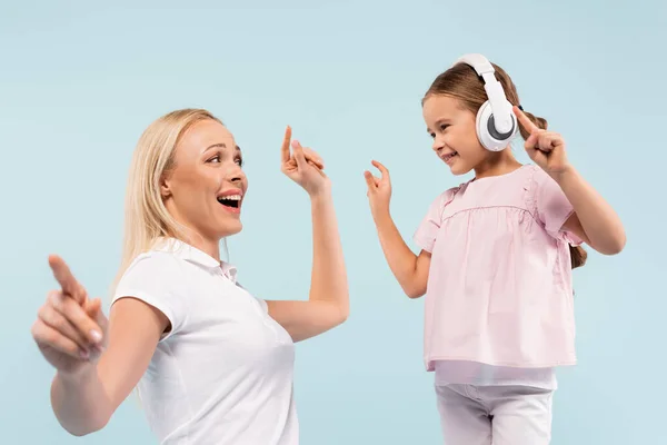 Niño Feliz Auriculares Inalámbricos Bailando Con Madre Alegre Aislado Azul — Foto de Stock