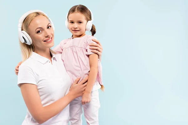 Felice Madre Cuffie Senza Fili Tenendo Braccio Bambino Isolato Blu — Foto Stock