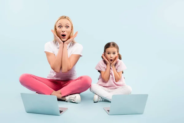 Şok Olmuş Anne Kız Dizüstü Bilgisayarların Yanında Mavi Dizüstü Bilgisayarlarla — Stok fotoğraf