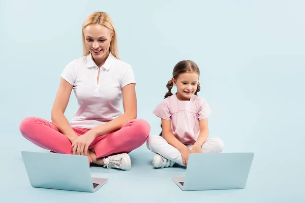 Happy Mother Daughter Sitting Crossed Legs Laptops Blue — Stock Photo, Image