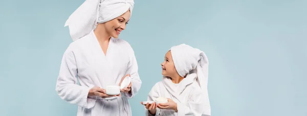 Feliz Madre Niño Batas Baño Sosteniendo Recipientes Con Crema Cosmética — Foto de Stock