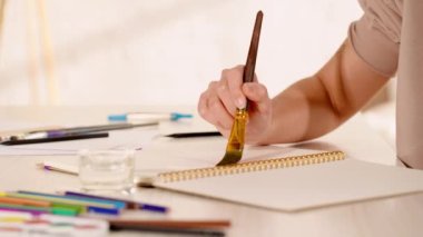 Kağıt üzerinde fırçayla resim yapan kadının kısmi görüntüsü