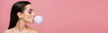 Çıplak omuzlu esmer bir kadının yan görünüşü. Pembe, afişte izole edilmiş sakız üflüyor.