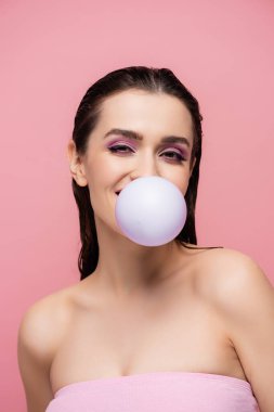 brunette woman with bare shoulders blowing bubblegum isolated on pink clipart