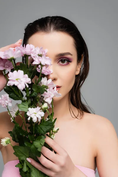 Mujer Joven Con Sombras Ojos Rosados Mirando Cámara Sosteniendo Flores — Foto de Stock