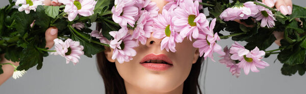 молодая женщина закрывая глаза розовыми цветами изолированы на сером, баннер