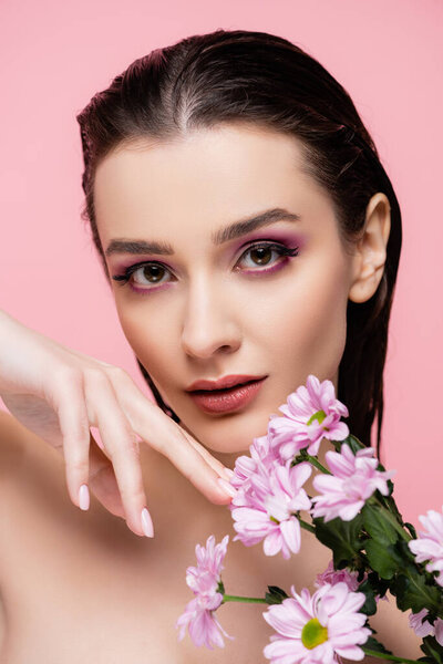 молодая чувственная женщина держит цветы изолированы на розовый