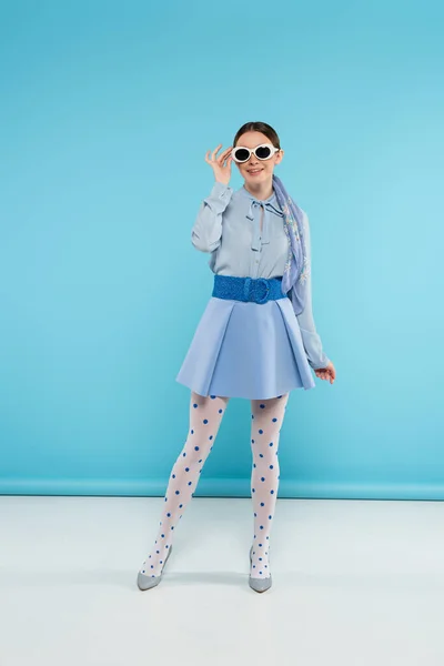 Lächelnde Frau Trendiger Kleidung Mit Sonnenbrille Während Sie Auf Blauem — Stockfoto