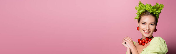 очаровательная женщина в шляпе, ожерелье и серьги из овощей на розовом, баннер