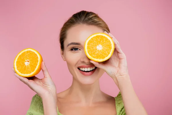 开朗的女人 用半熟橙包裹眼睛 用粉红隔开 — 图库照片