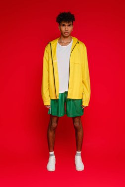 Kırmızı üzerine poz veren Afrikalı Amerikalı bir adam.