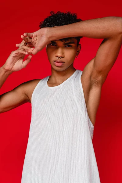 Beyaz atletli kaslı Afro-Amerikan adam kırmızıda izole edilmiş.