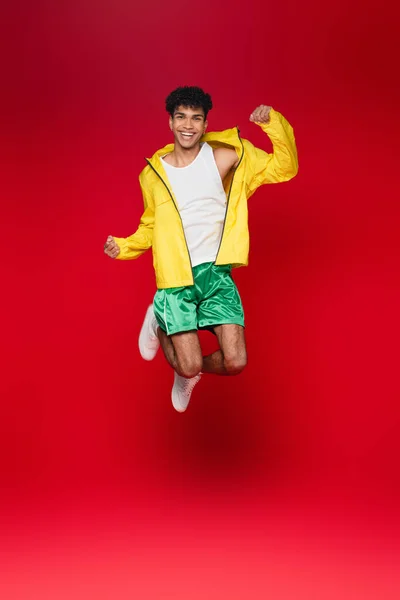 Full Length Smiling African American Man Yellow Jacket Jumping Red — Stock Photo, Image