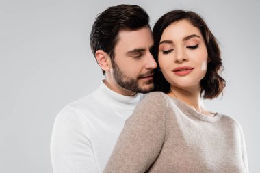 Gözleri kapalı genç bir adam, Gri yolda karısının yanında duruyor. 