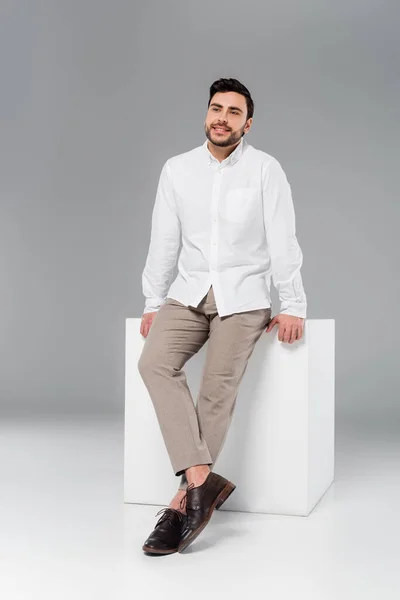 Elegante Hombre Sonriendo Cerca Cubo Blanco Sobre Fondo Gris — Foto de Stock