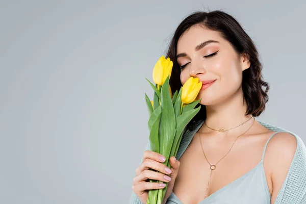 Jovem Mulher Cheirando Tulipas Amarelas Isoladas Cinza — Fotografia de Stock