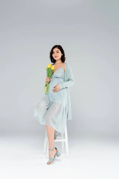 Smiling Pregnant Woman Holding Tulips Chair Grey Background — Stock Photo, Image