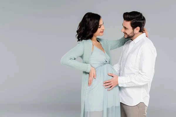 笑顔男タッチベリーの妊娠中の妻でドレス絶縁上のグレー — ストック写真