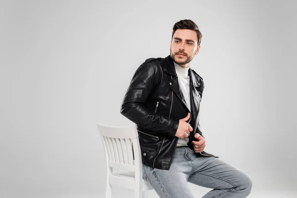 Bearded Man Leather Jacket Looking Away Chair Isolated Grey — Stock Photo, Image