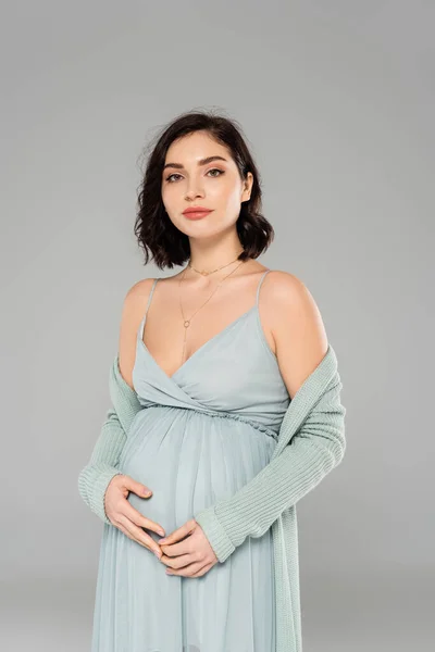 妊娠中の女性でドレス見ますでカメラ孤立オングレー — ストック写真
