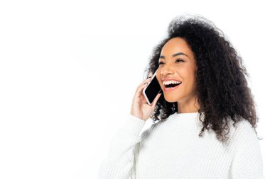 Gülen Afro-Amerikan kadın akıllı telefondan konuşuyor. Gözünü beyazdan ayırmıyor.