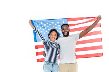 joyful african american couple holding usa flag while looking at camera isolated on white clipart