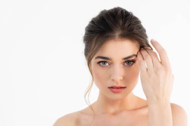 Çıplak omuzlu çekici bir kadın beyaz kameraya bakıyor.