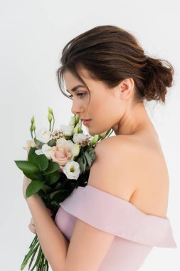 Çekici nişanlısı beyaz bir buketle poz veriyor.