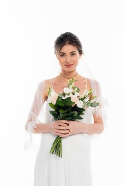 happy, pregnant bride looking at camera while holding wedding bouquet isolated on white clipart