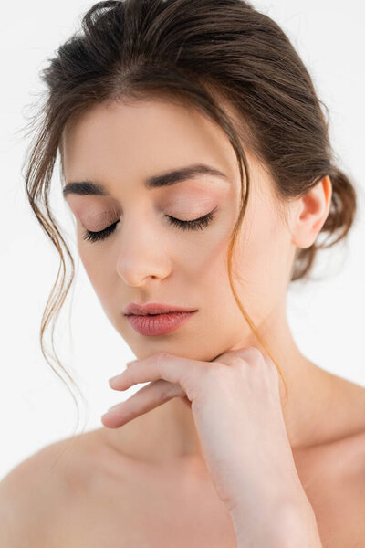 молодая женщина с натуральным макияжем позирует с закрытыми глазами изолированы на белом
