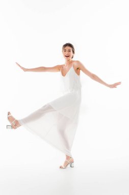 Neşeli gelinin beyaz üzerinde dans ederken kameraya uzun uzun bakışıyla.