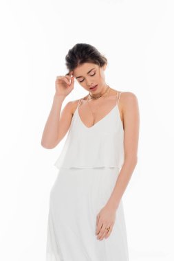 Gelinlik giymiş genç bir kadın. Yüzüne yakın duran beyaz tenli bir kadın.