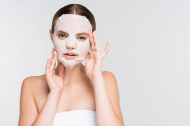 Nemlendirici çarşaf maskeli genç bir kadın beyaza izole edilmiş.