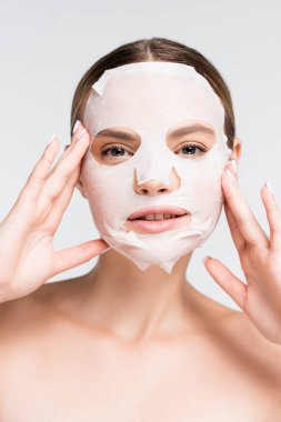 Çıplak omuzlu, nemlendirici çarşaf maskeli genç bir kadın.