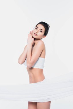 İç çamaşırlı genç bir kadın kameraya bakıyor. 