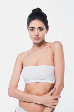 İç çamaşırlı zayıf bir kadın beyaz kameraya bakıyor. 