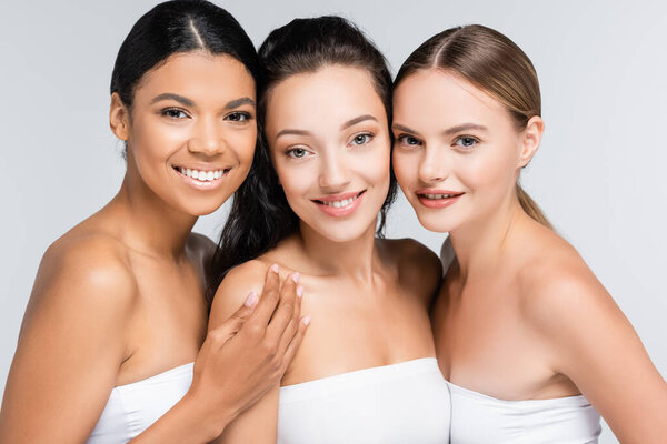 веселые многоэтнические женщины с обнаженными плечами, изолированными на сером