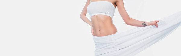 Обрезанный вид женщины в бюстгальтере держа ткань изолированы на белом, баннер 