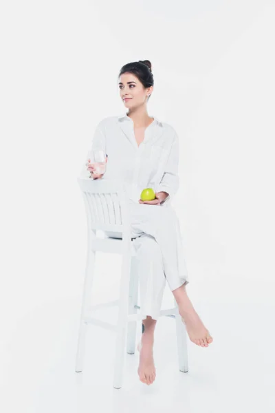 Красива Жінка Тримає Яблуко Воду Сидячи Білому Стільці Білому Тлі — стокове фото
