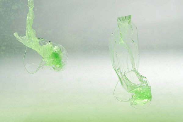 использованные пластиковые пакеты и чашки в воде, экологическая концепция