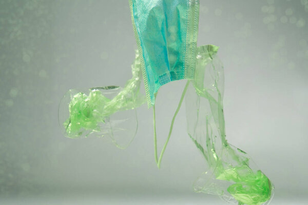 пластиковые пакеты и стаканы возле медицинской маски под водой, экологическая концепция