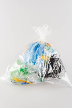 globe packed in cellophane bag with plastic rubbish on grey, ecology concept clipart