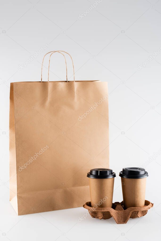 paper bag and disposable cups on grey, ecology concept