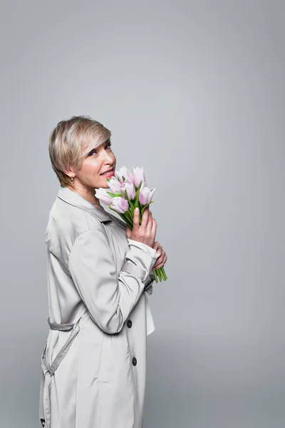 Middle Aged Woman Grey Trench Coat Posing Fresh Tulips Isolated — Φωτογραφία Αρχείου