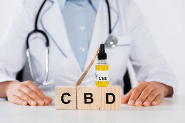 CBC harfleriyle şişenin yanında doktor manzarası ve tahta küplerle eklem. 