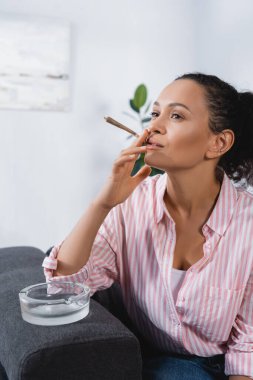 Afro-Amerikan kadın sigara sarılmış esrar ile kül tablası yanında tıbbi esrar 