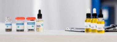 Klinikteki panonun yanında tıbbi kenevir ve cbd harfleri olan şişeler, afiş.