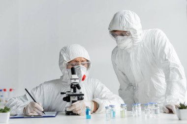 Bilim adamları aşıyı ve yazıyı laboratuardaki panoda araştırıyorlar. 