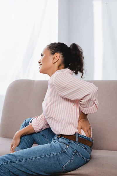 African American Woman Suffering Back Pain While Sitting Couch — Stock Photo, Image